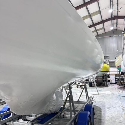 Wrapped yacht hull on its cradle being measured for a cover