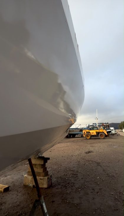 Close-up of a yacht hull under taut shrink wrap, blocked off ashore