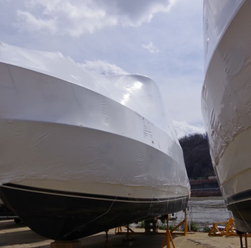 Shrink wrapped motor boat hulls ashore